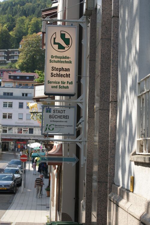 Datei:Hinweisschild Stadtbibliothek und Orthopodie-Schumacher.JPG