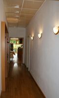 Gang zum Nebenzimmer Gartenseite mit Garderobe und Toiletteneingang mit Blick zur Theke im Eingangsbereich