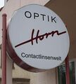 Firmenschild von Optik Horn in der Straße